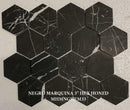 Hexagonal black marble tiles with white veins on a beige background