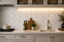 Mona Dolomite mosaic tile with blue dot pattern from Mythology Tile, polished marble backsplash featuring a decorative geometric design.