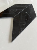 Nero Marquina chevron marble mosaic creating a sophisticated bathroom wall design
